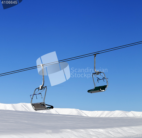 Image of Chair-lift and blue clear sky at sun day