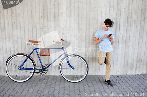 Image of man with smartphone and earphones on bicycle