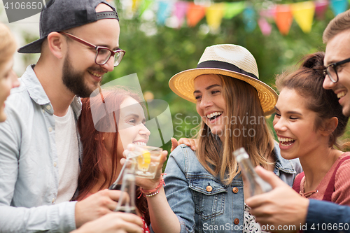 Image of happy friends clinking glasses at summer garden