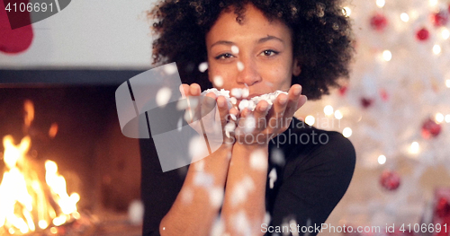 Image of Adorable sexy woman blowing out confetti