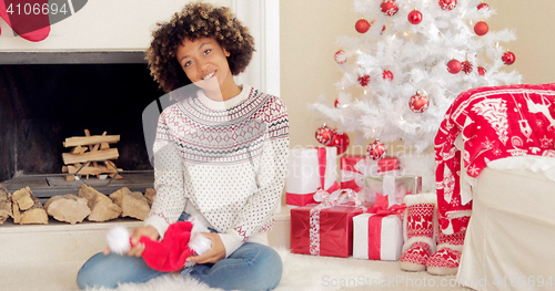 Image of Smiling young woman holding a Santa hat