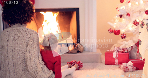 Image of Mother and child warm up by the fireplace