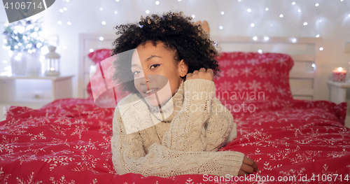 Image of Pretty young African woman in a festive bedroom