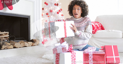 Image of Surprised woman holding a large Christmas gift