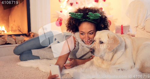 Image of Cute young woman taking a selfie with her dog