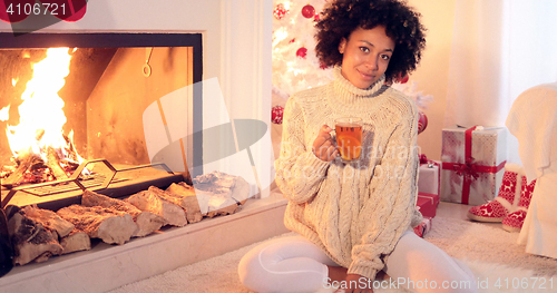 Image of Happy young woman relaxing at Christmas