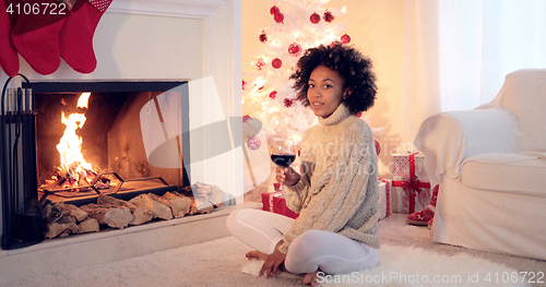 Image of Woman in leggings and sweater sits by white tree