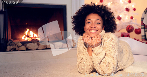 Image of Woman by fireplace and wearing warm sweater