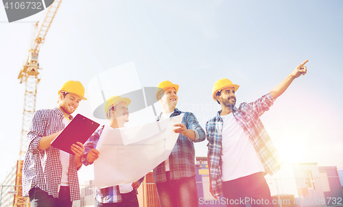 Image of group of builders with tablet pc and blueprint