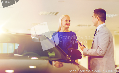 Image of happy woman with car dealer in auto show or salon