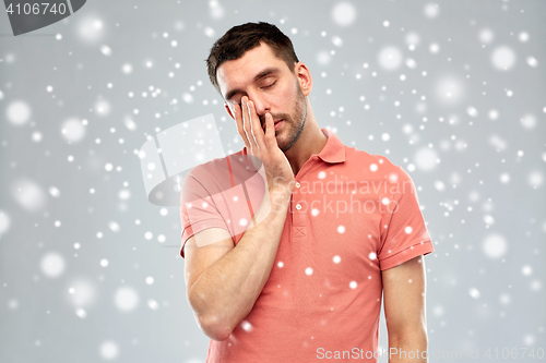 Image of tired sleepy man over snow