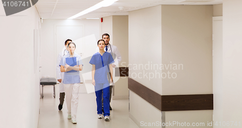 Image of group of medics or doctors walking along hospital