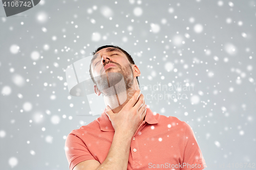 Image of man touching neck and suffering from throat pain