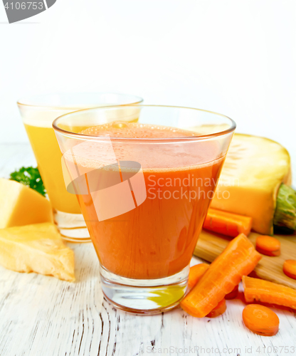 Image of Juice carrot and pumpkin with vegetables on light board