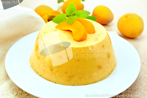 Image of Panna cotta apricot with mint and fruit on table