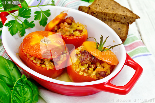 Image of Tomatoes stuffed with bulgur in pan on board