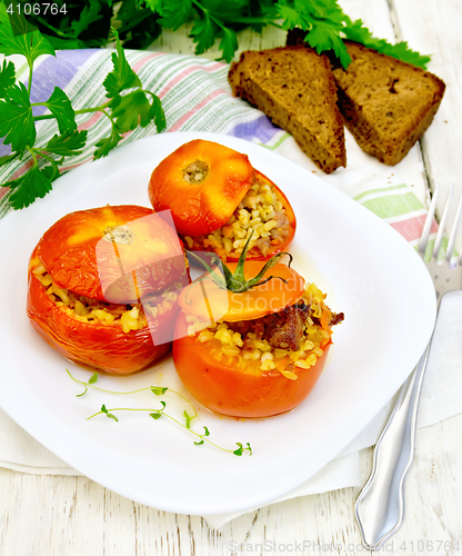 Image of Tomatoes stuffed with bulgur in plate on board