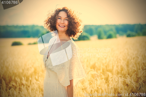 Image of beautiful woman in a white dress in a wheat field