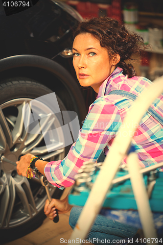 Image of woman pulls the wheel bolts