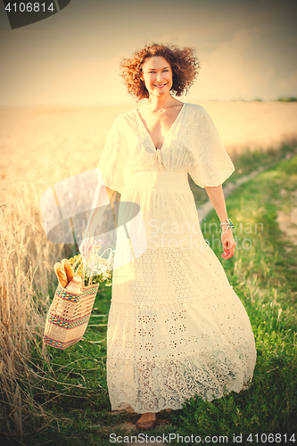 Image of Pretty smiling Woman Outdoors with wicker bag with natural meal 