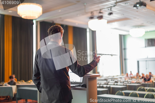 Image of Public speaker giving talk at business event.