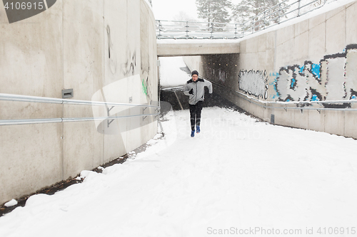 Image of man running out of subway tunnel in winter