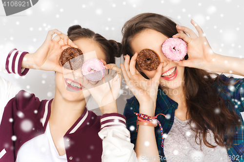 Image of happy pretty teenage girls with donuts having fun