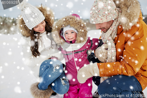 Image of happy family with child in winter clothes outdoors