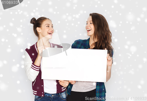 Image of smiling teenage girls holding white blank board