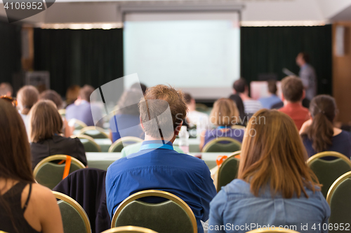 Image of Audience in lecture hall participating at business conference.