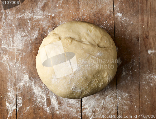 Image of bowl of fresh dough on rustic wooden table