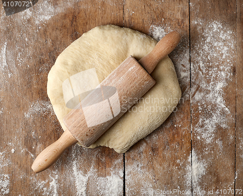 Image of fresh raw dough and rolling pin 