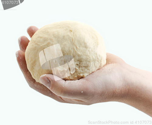 Image of fresh raw dough in bakers hand