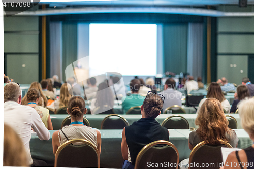 Image of Audience in lecture hall participating at business conference.