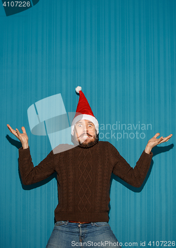 Image of Surprised christmas man wearing a santa hat