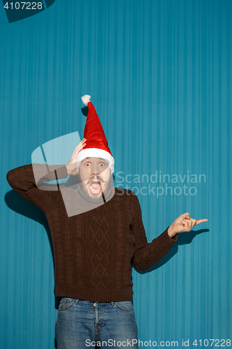 Image of Surprised christmas man wearing a santa hat