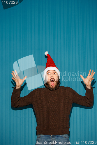 Image of Surprised christmas man wearing a santa hat