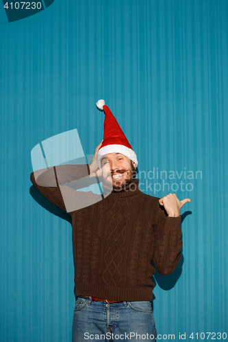 Image of Smiling christmas man wearing a santa hat