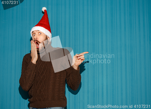 Image of Surprised christmas man wearing a santa hat