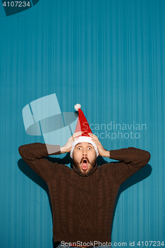 Image of Surprised christmas man wearing a santa hat