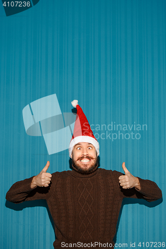 Image of Smiling christmas man wearing a santa hat