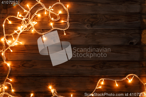 Image of Christmas and new year dark brown wooden background decorated lightbulbs