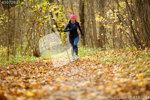 Image of Sportswoman in sportswear running autumn