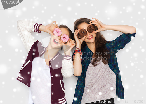 Image of happy pretty teenage girls with donuts having fun