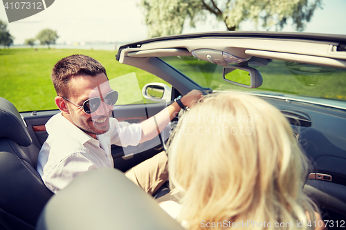 Image of happy man and woman driving in cabriolet car