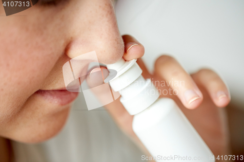 Image of close up of sick woman using nasal spray