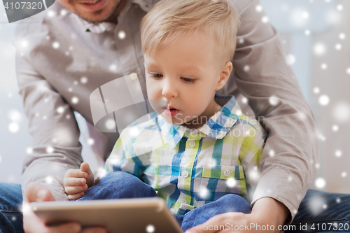 Image of father and son with tablet pc playing at home