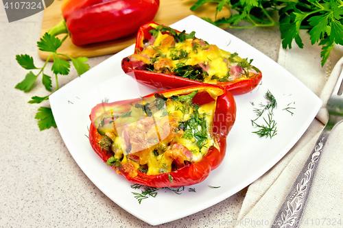 Image of Pepper stuffed with sausage and cheese in white plate on granite