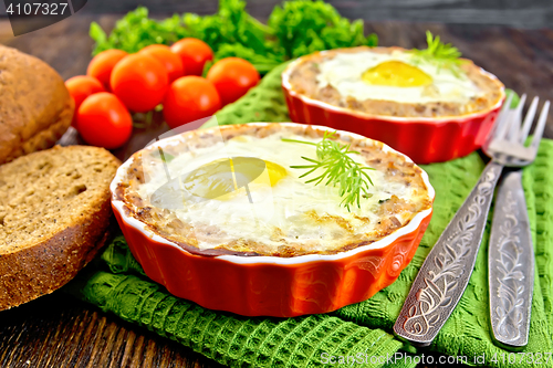 Image of Tartlet meat with egg in pan on board