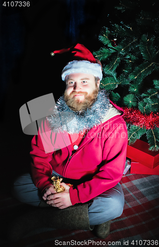 Image of Man Dressed As Santa Sitting Under The Christmas Tree